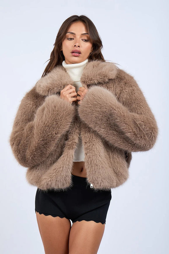 Woman wearing a fluffy brown jacket on a white background